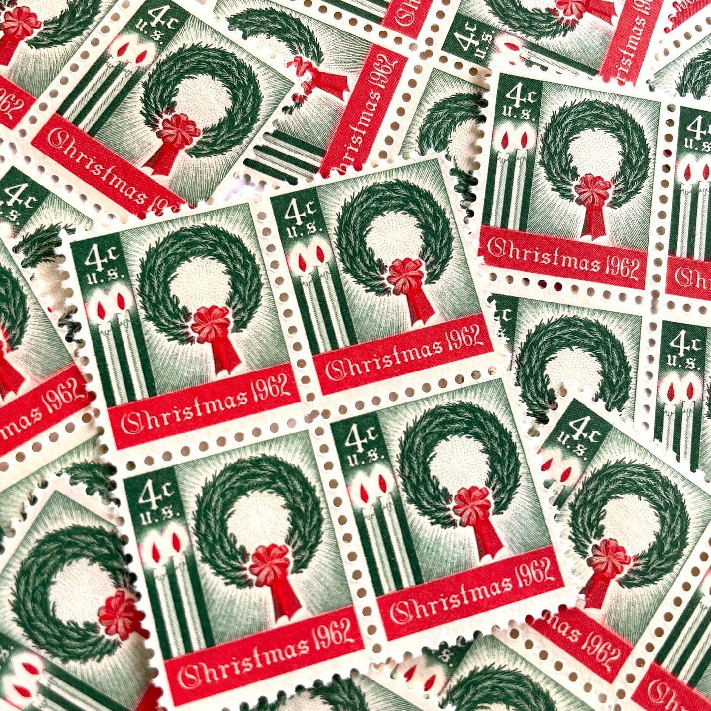 Image of 1962 Contemporary Christmas “Christmas Wreath and Candles” 4-cent stamps. Scott #1205. Stamp Themes: Wreath, Candles, Red Bow, Holidays, First U.S. Christmas Stamp. Green and red postage stamp.