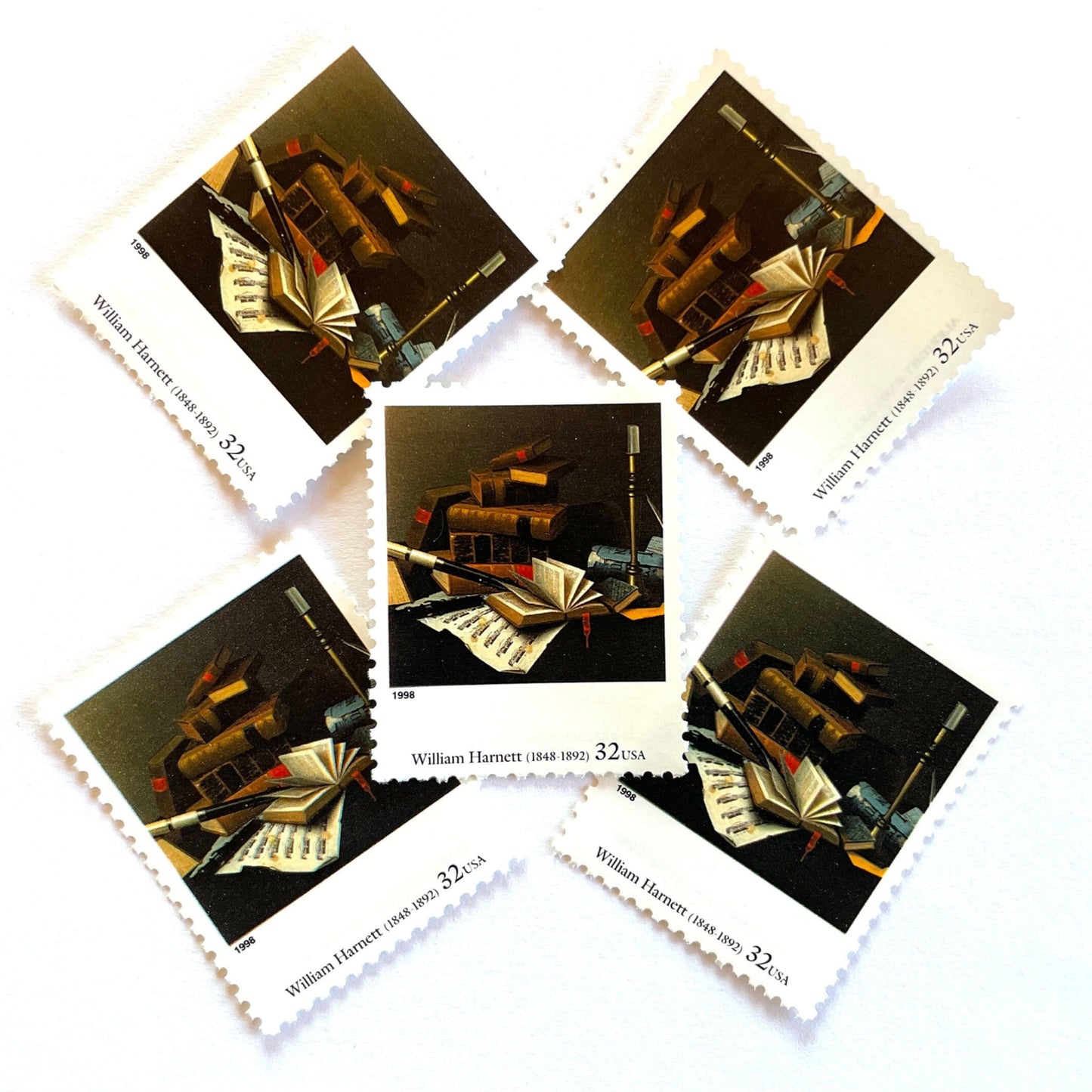 William Harnett’s “Music and Literature" Postage Stamp from the 1998 Four Centuries of American Art Series. This stamp depicts a still life painting of stacked books, sheet music, and a musical instrument. An iconic scholarly theme, this postage stamp is often used to mail wedding invitations. These are vintage unused USPS postage stamps with a face value of 32 cents each. Scott number 3236I.