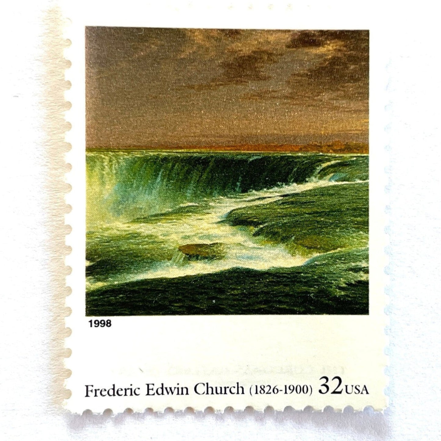 Close up image of Frederic Edwin Church’s “Niagara” Postage Stamp from the 1998 Four Centuries of American Art Series. This stamp depicts the iconic landscape painting of Niagara Falls. An iconic nature theme, this stamp predominately green postage stamp depicts the waterfall that is shared by the United States and Canada and is a favorite honeymoon destination. These are vintage unused USPS postage stamps with a face value of 32 cents each. Scott number 3236N.