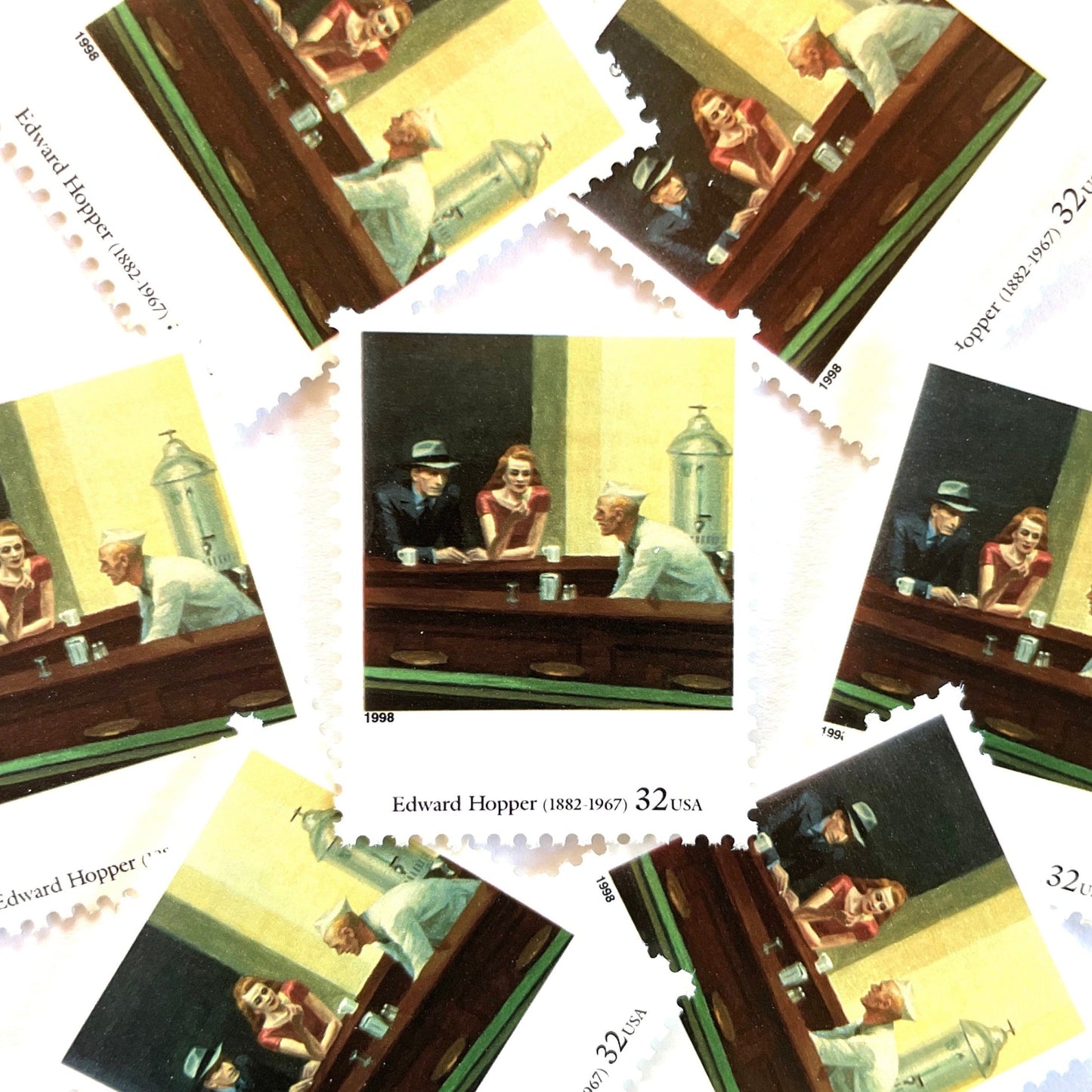 Edward Hopper’s “Nighthawks" Postage Stamp from the 1998 Four Centuries of American Art Series. This stamp depicts the iconic painting of a man and woman, both elegantly dressed, sitting at a diner counter late at night drinking coffee, while a waiter, dressed in white, prepares their pie. An iconic urban living theme, this stamp depicts the classic American diner experience. These are vintage unused USPS postage stamps with a face value of 32 cents each. Scott number 3236P.