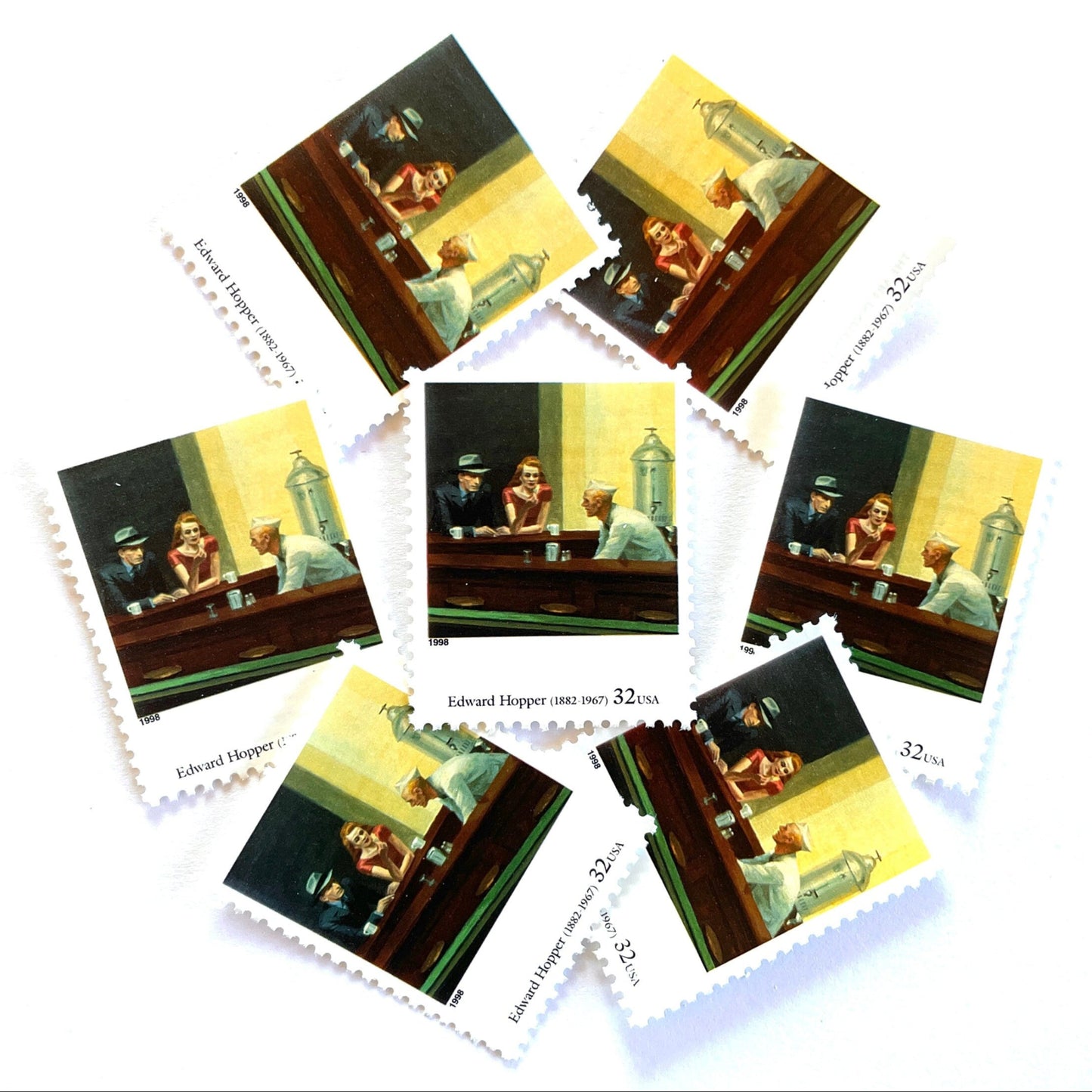 Edward Hopper’s “Nighthawks" Postage Stamp from the 1998 Four Centuries of American Art Series. This stamp depicts the iconic painting of a man and woman, both elegantly dressed, sitting at a diner counter late at night drinking coffee, while a waiter, dressed in white, prepares their pie. An iconic urban living theme, this stamp depicts the classic American diner experience. These are vintage unused USPS postage stamps with a face value of 32 cents each. Scott number 3236P.
