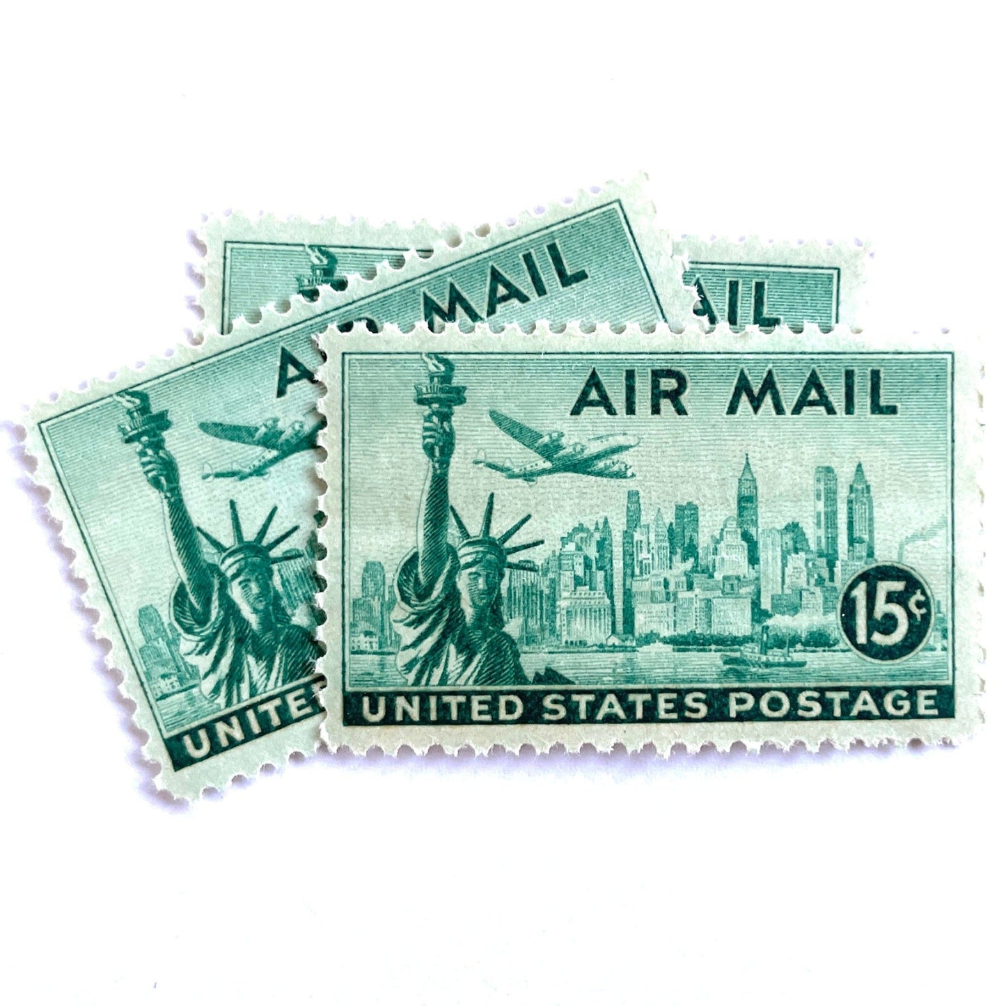 Image of 1947 “New York Skyline” 15-cent Air Mail stamps. Scott #C35. Stamp Themes: New York, NYC, Big Apple, Statue of Liberty, Chrysler Building, Air Mail, Air Travel, Transportation. Green postage stamp.