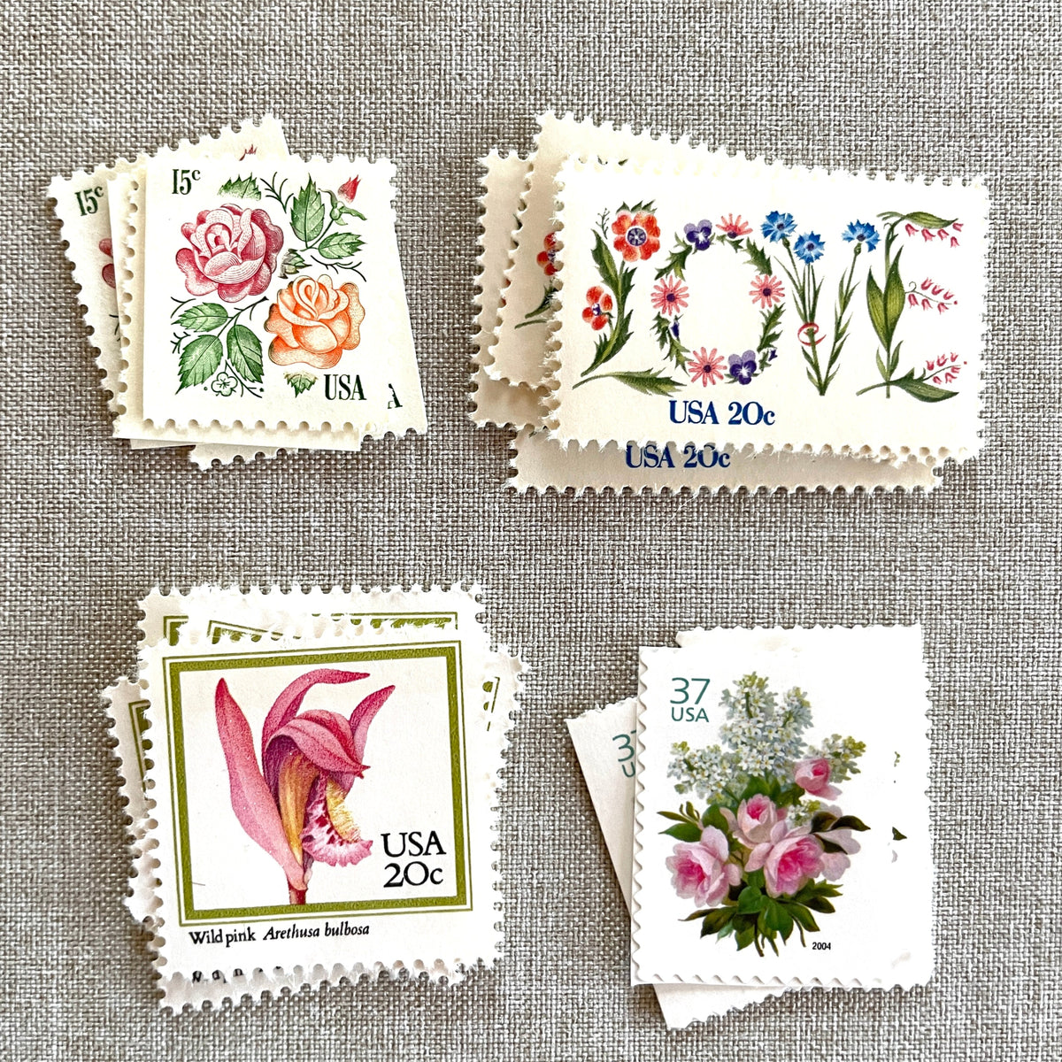 Image of four unused vintage stamps curated and arranged in a USPS postage stamp set for mailing floral and love-themed save-the-dates, wedding invitations, bridal shower invitations, and other special correspondence. This postage stamp set is called the “Pink Floral Love” set, is botanically themed, with pink as the predominant color. The total face value of the set is 92-cents USD.
