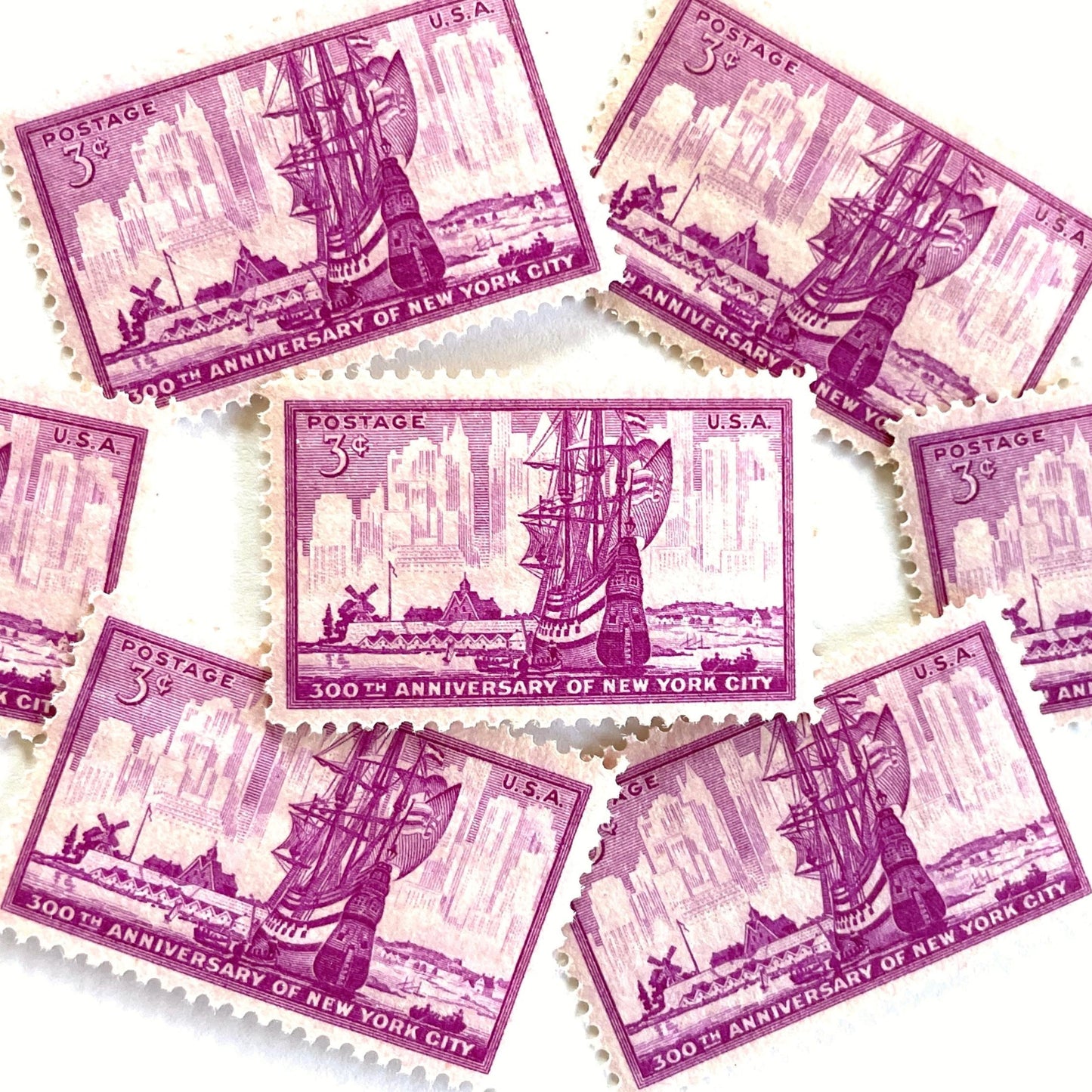 Image of 1953 “New York City” 300th Anniversary 3-cent mail stamps. Scott #1027. Stamp Themes: New York City, NYC, Big Apple, New Amsterdam, Dutch Settlement, New York Skyline, Sailing. Red/violet postage stamp.