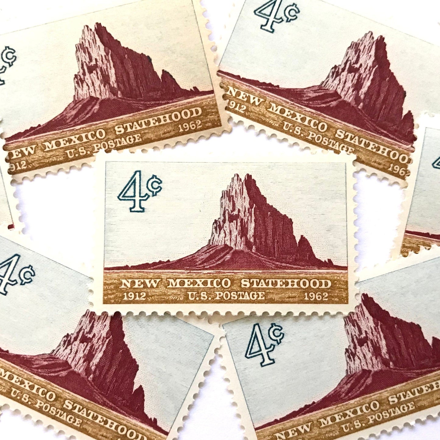 Image of New Mexico Statehood postage stamps from 1962, featuring a Southwestern desert landscape associated with Shiprock on vintage unused 4-cent USPS postage, Scott 1191.