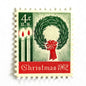 Image of 1962 Contemporary Christmas “Christmas Wreath and Candles” 4-cent stamps. Scott #1205. Stamp Themes: Wreath, Candles, Red Bow, Holidays, First U.S. Christmas Stamp. Green and red postage stamp.