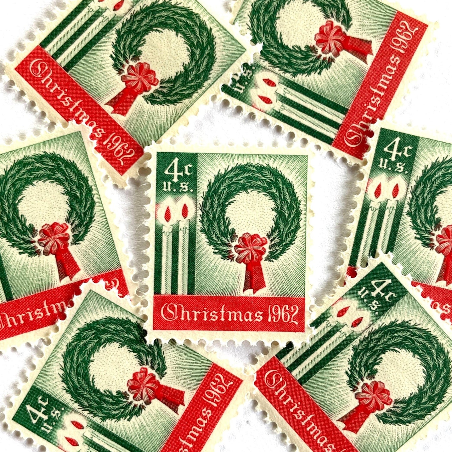Image of 1962 Contemporary Christmas “Christmas Wreath and Candles” 4-cent stamps. Scott #1205. Stamp Themes: Wreath, Candles, Red Bow, Holidays, First U.S. Christmas Stamp. Green and red postage stamp.
