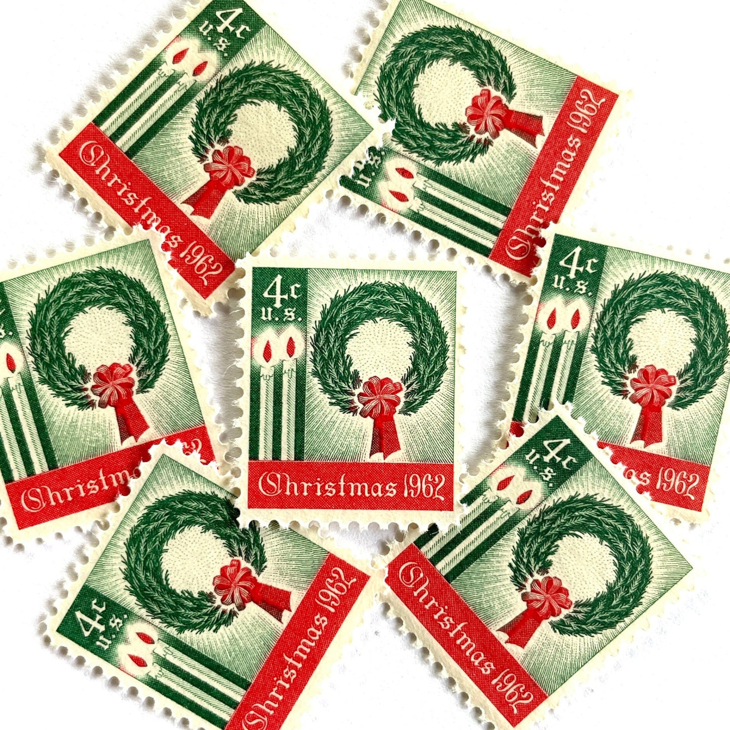 Image of 1962 Contemporary Christmas “Christmas Wreath and Candles” 4-cent stamps. Scott #1205. Stamp Themes: Wreath, Candles, Red Bow, Holidays, First U.S. Christmas Stamp. Green and red postage stamp.