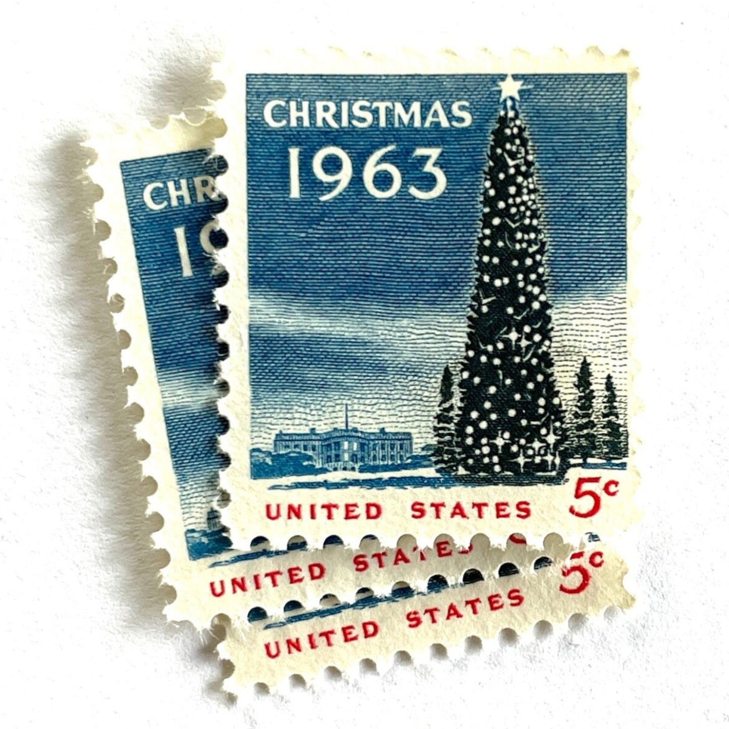 Image of 1963 “Christmas Tree and White House” 5-cent stamps. Scott #1240. Stamp Themes: National Christmas Tree, The White House, Capitol, Washington DC, Winter Christmas Scene, Holidays. Blue, white, red postage stamp.