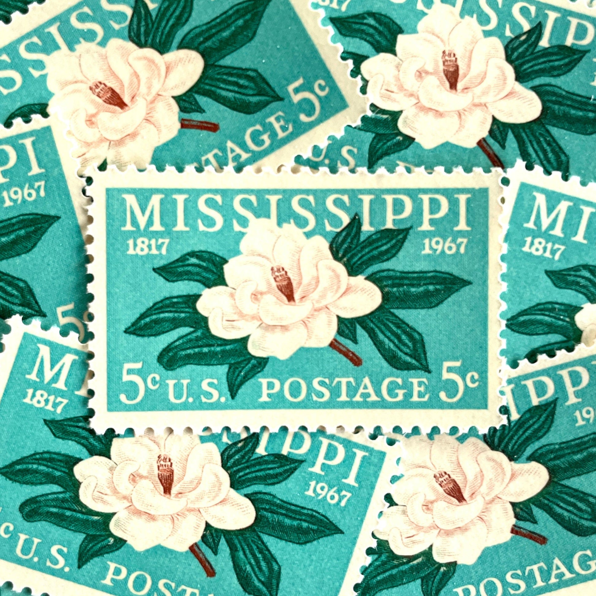 Image of Mississippi Statehood postage stamps from 1967, featuring a magnolia flower design on vintage unused 5-cent USPS postage, Scott 1337.
