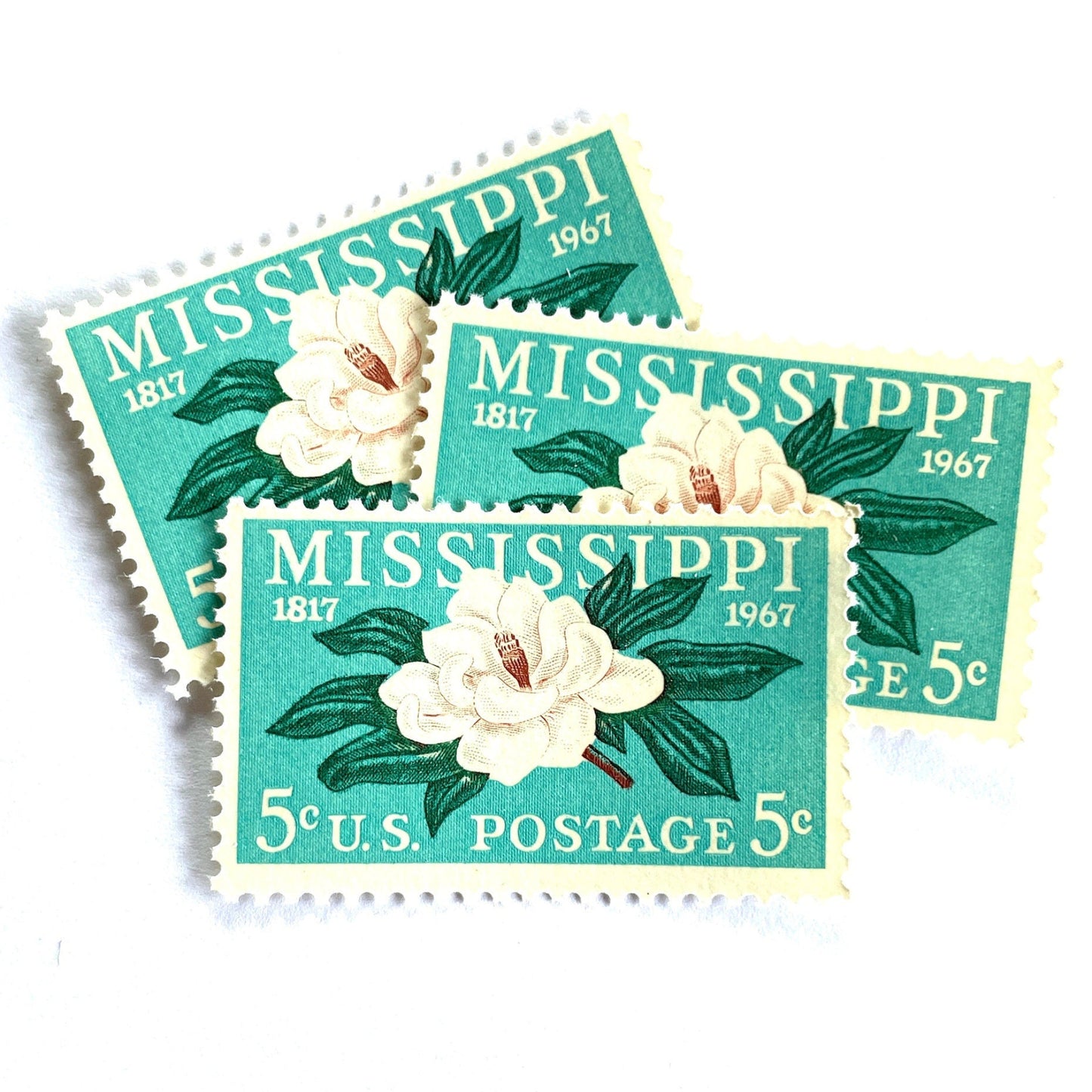 Image of Mississippi Statehood postage stamps from 1967, featuring a magnolia flower design on vintage unused 5-cent USPS postage, Scott 1337.