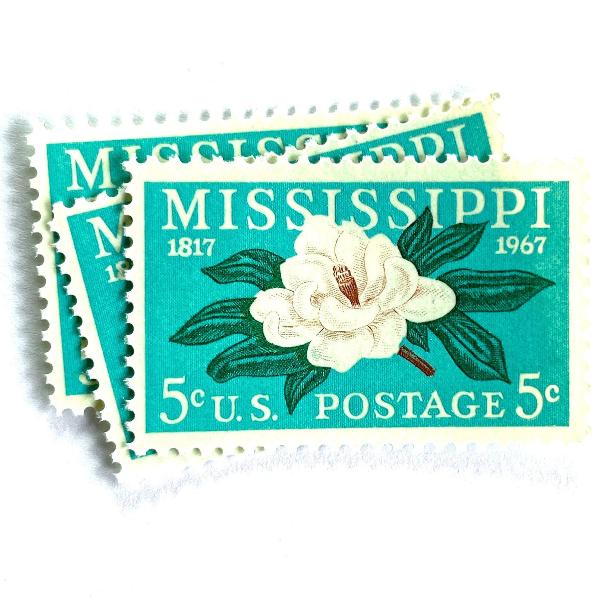 Image of Mississippi Statehood postage stamps from 1967, featuring a magnolia flower design on vintage unused 5-cent USPS postage, Scott 1337.