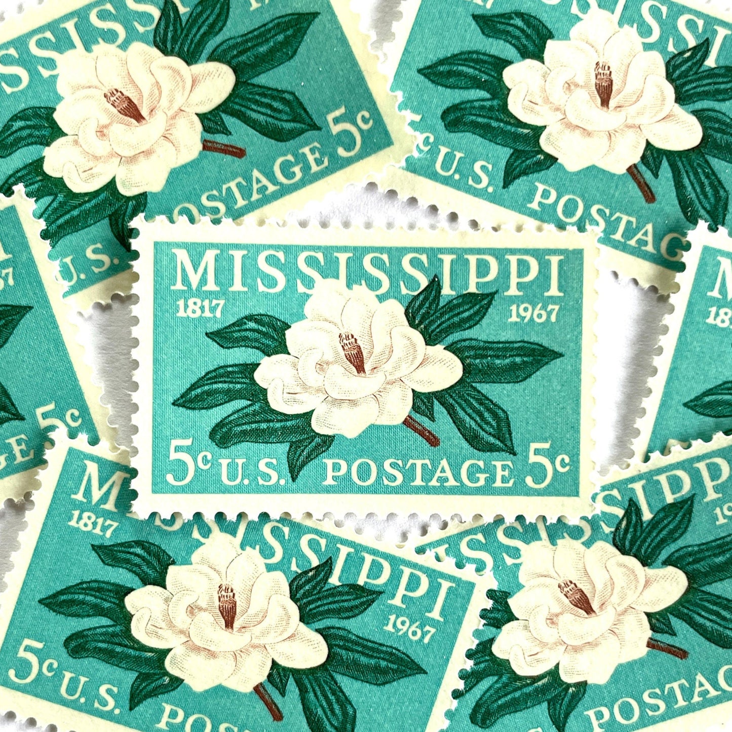 Image of Mississippi Statehood postage stamps from 1967, featuring a magnolia flower design on vintage unused 5-cent USPS postage, Scott 1337.
