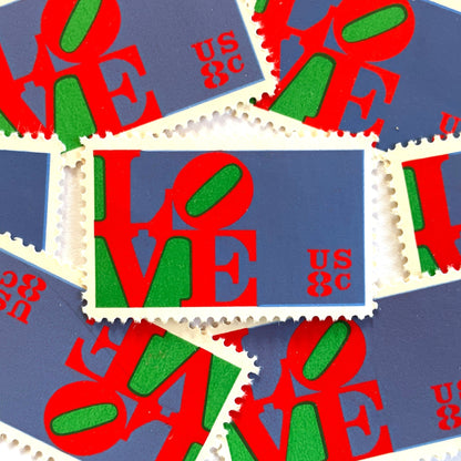 Red LOVE postage stamps from 1973 featuring Robert Indiana’s iconic red, green, and violet blue LOVE design on vintage unused 8-cent USPS postage, Scott 1475.