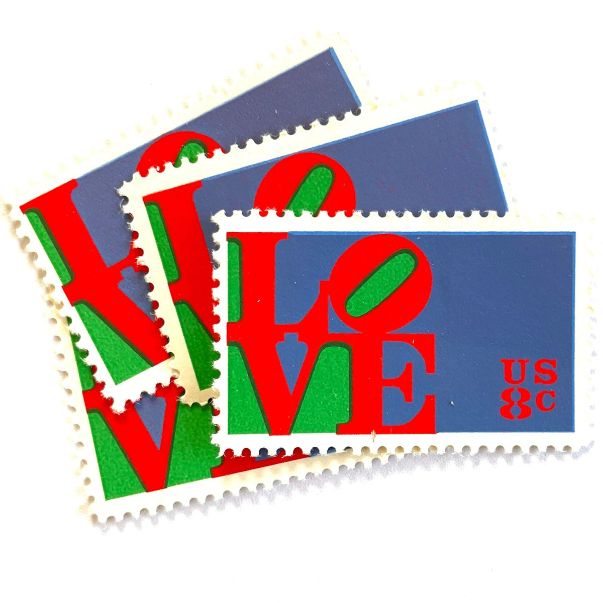 Red LOVE postage stamps from 1973 featuring Robert Indiana’s iconic red, green, and violet blue LOVE design on vintage unused 8-cent USPS postage, Scott 1475.