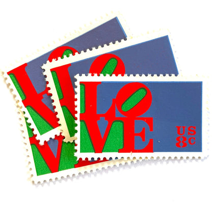 Red LOVE postage stamps from 1973 featuring Robert Indiana’s iconic red, green, and violet blue LOVE design on vintage unused 8-cent USPS postage, Scott 1475.