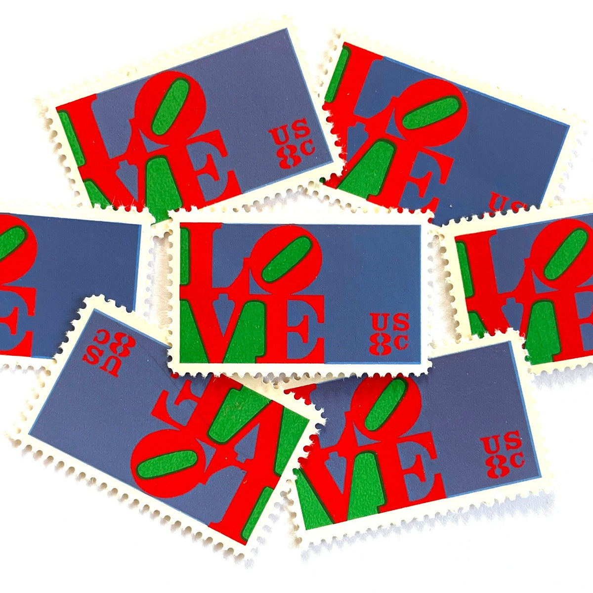 Red LOVE postage stamps from 1973 featuring Robert Indiana’s iconic red, green, and violet blue LOVE design on vintage unused 8-cent USPS postage, Scott 1475.