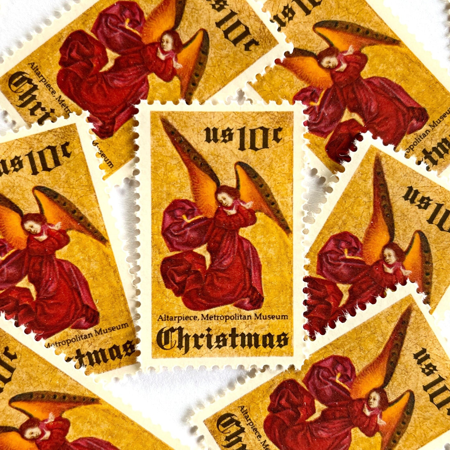 Image of 1974 Traditional Christmas “Angel Altarpiece” 10-cent stamps. Scott #1550. Stamp Themes: Christmas, Holidays, Religious, Altar, Angel, Angel Wings, The Met, Metropolitan Museum of Art, NYC, New York. Red, gold postage stamp.