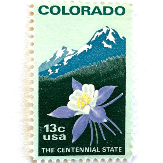 Vintage Colorado Statehood postage stamp from 1977 featuring the Rocky Mountains and Colorado columbine on unused blue/green 13-cent USPS postage, Scott 1711.
