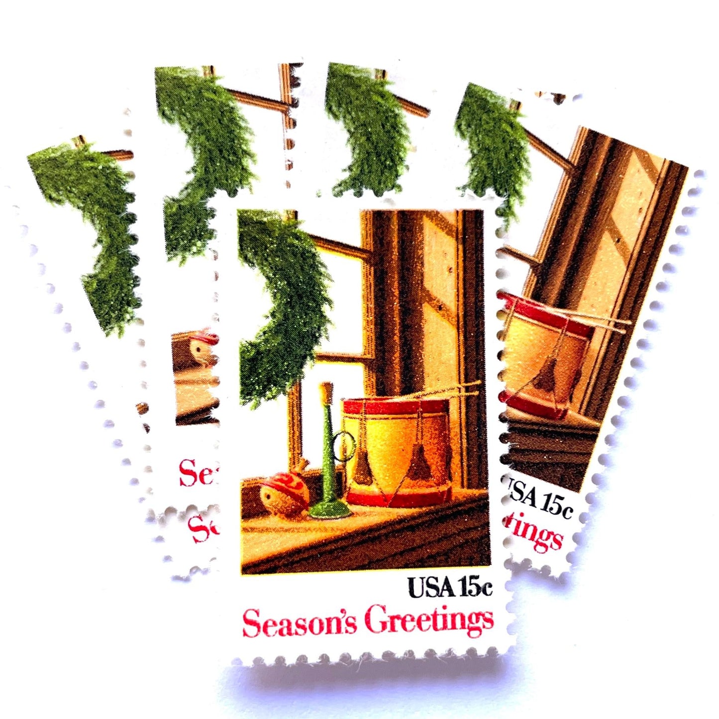 Image of 1980 Contemporary Christmas “Wreath and Toys on Window” 15-cent stamps. Scott #1843. Stamp Themes: Christmas, Holidays, Toys, Musical Instruments, Drum, Horn, Spinning Top. Multicolored postage stamp.