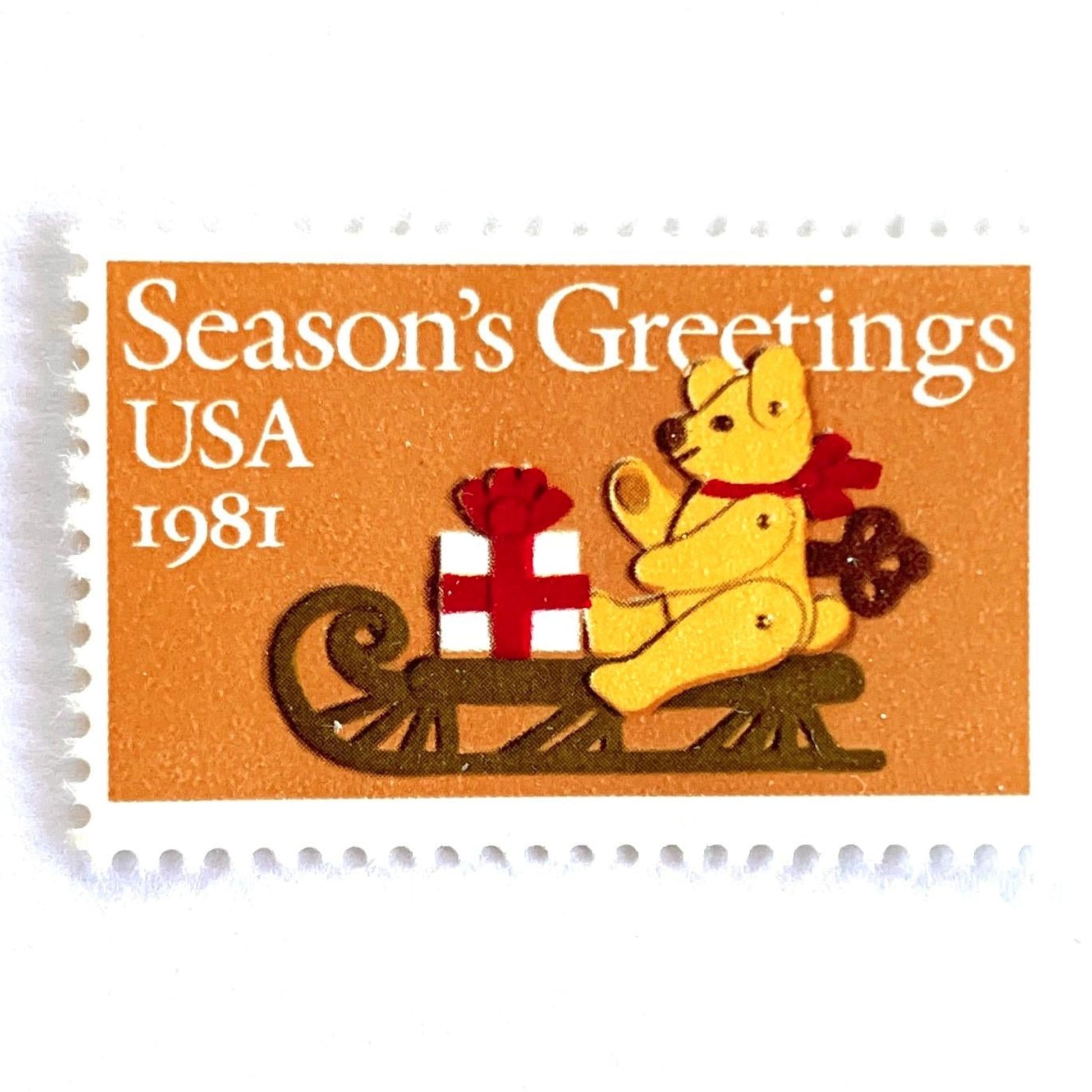 Image of 1981 Contemporary Christmas “Teddy Bear with Sleigh” 20-cent stamps. Scott #1940. Stamp Themes: Christmas, Holidays, Presents, Gifts, Sleigh, Wind-up Toy, Season’s Greetings. Gold/Beige postage stamp.