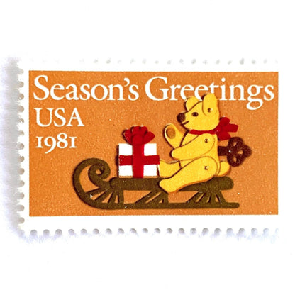Image of 1981 Contemporary Christmas “Teddy Bear with Sleigh” 20-cent stamps. Scott #1940. Stamp Themes: Christmas, Holidays, Presents, Gifts, Sleigh, Wind-up Toy, Season’s Greetings. Gold/Beige postage stamp.