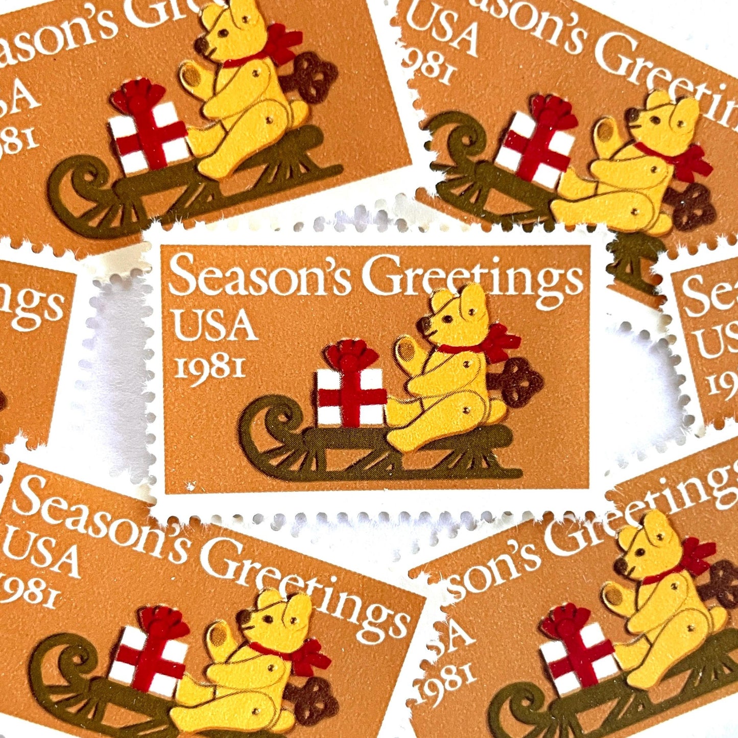 Image of 1981 Contemporary Christmas “Teddy Bear with Sleigh” 20-cent stamps. Scott #1940. Stamp Themes: Christmas, Holidays, Presents, Gifts, Sleigh, Wind-up Toy, Season’s Greetings. Gold/Beige postage stamp.
