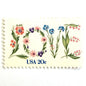 Love Flowers postage stamp from 1982 featuring the word LOVE formed with colorful flowers on vintage unused 20-cent USPS postage, Scott 1951.