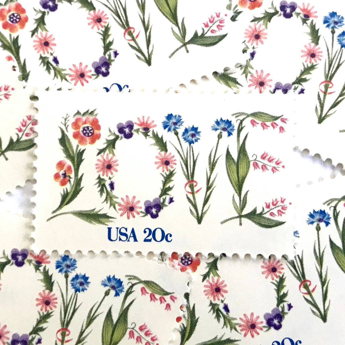 Love Flowers postage stamps from 1982 featuring the word LOVE formed with colorful flowers on vintage unused 20-cent USPS postage, Scott 1951.