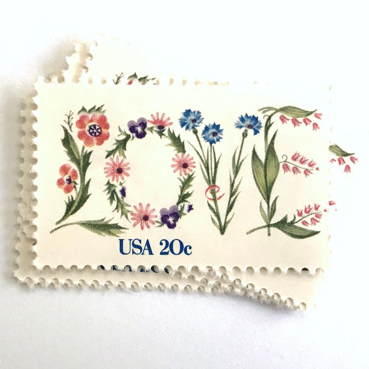 Love Flowers postage stamps from 1982 featuring the word LOVE formed with colorful flowers on vintage unused 20-cent USPS postage, Scott 1951.