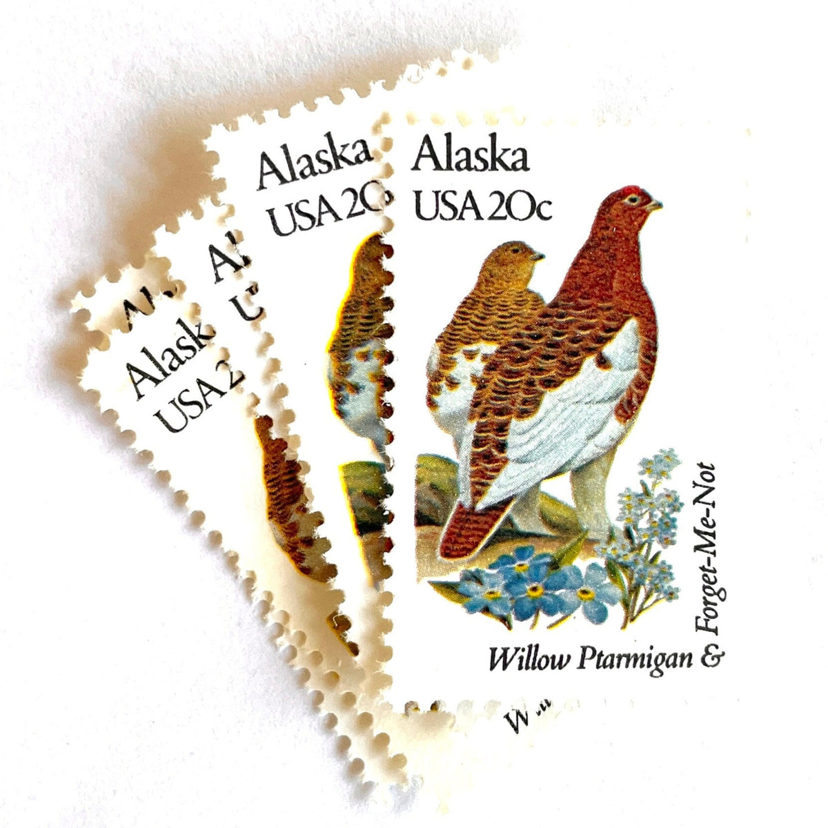 Alaska State Bird and Flower postage stamps from 1982 featuring a Willow Ptarmigan and Forget-Me-Not on vintage unused 20-cent USPS postage, Scott 1954.