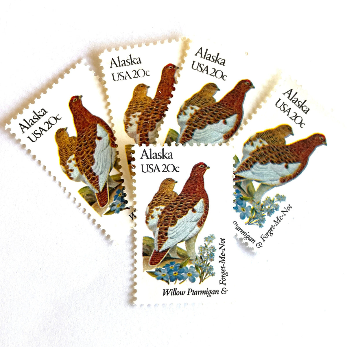 Alaska State Bird and Flower postage stamps from 1982 featuring a Willow Ptarmigan and Forget-Me-Not on vintage unused 20-cent USPS postage, Scott 1954.