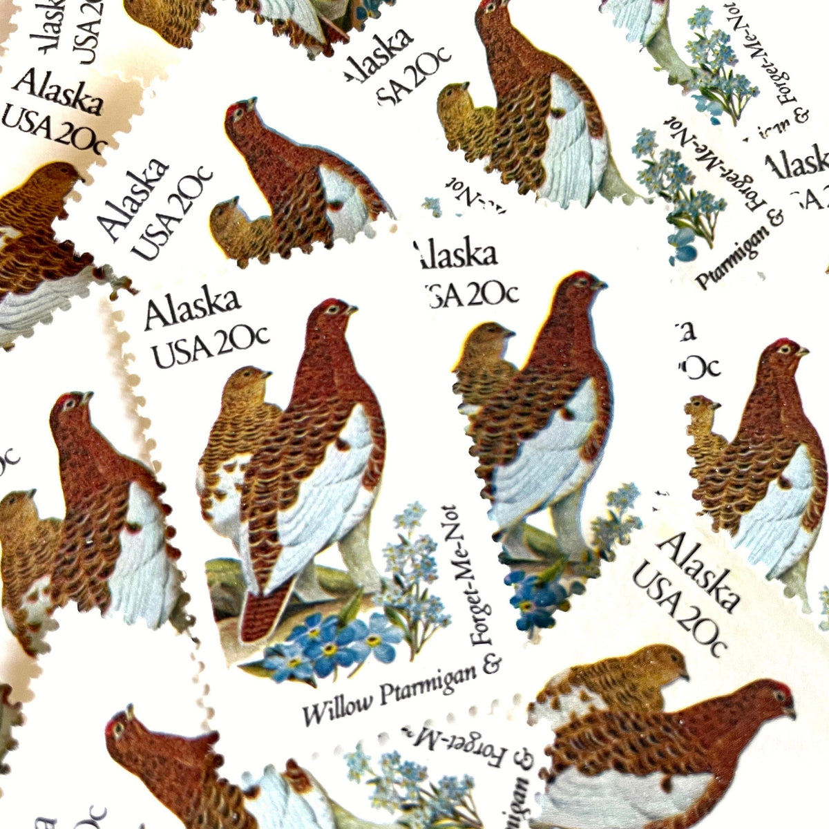 Alaska State Bird and Flower postage stamps from 1982 featuring a Willow Ptarmigan and Forget-Me-Not on vintage unused 20-cent USPS postage, Scott 1954.