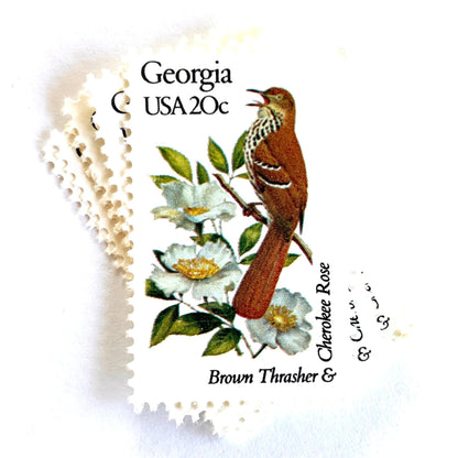 Image of Georgia State Bird and Flower postage stamps from 1982, featuring a Brown Thrasher and Cherokee Rose on vintage unused 20-cent USPS postage, Scott 1962.