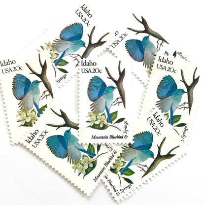 Image of Idaho State Bird and Flower postage stamps from 1982, featuring a Mountain Bluebird and Syringa on vintage unused 20-cent USPS postage, Scott 1964.