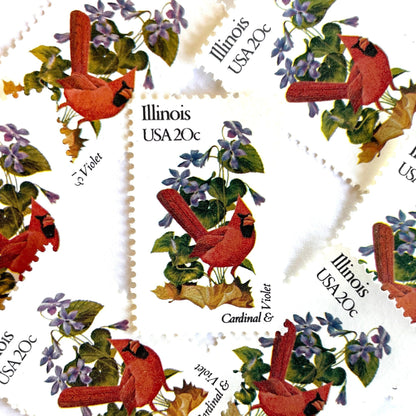 May include: Six vintage Illinois state commemorative postage stamps featuring a red cardinal and purple violets. Each stamp reads "Illinois USA 20c".