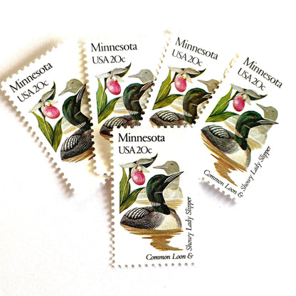 Image of Minnesota State Bird and Flower postage stamps from 1982, featuring a Common Loon and Pink and White Lady’s Slipper on vintage unused 20-cent USPS postage, Scott 1975.
