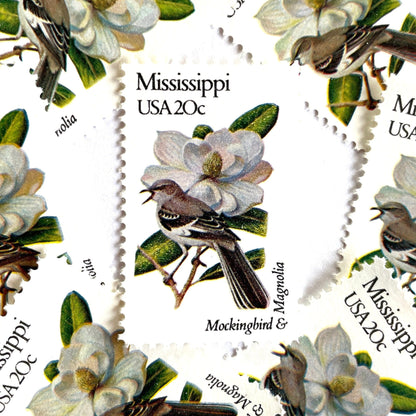 Image of 1982 State Birds & Flowers Mississippi (Mockingbird & Magnolia) 20 cent stamps. Scott #1976. Stamp themes: Birds, Aviary, Flowers, Flora, White Flower, Mississippi State Bird, Mississippi State Flower. White postage stamp.