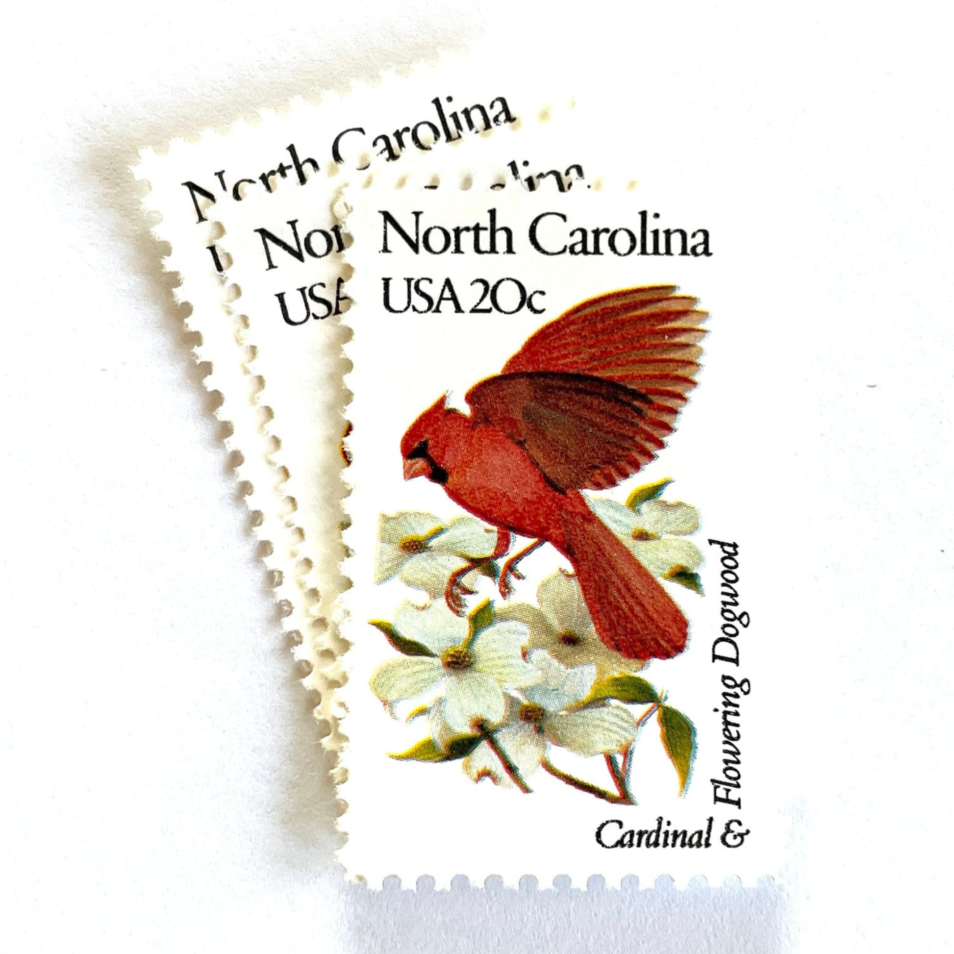 Image of North Carolina State Bird and Flower postage stamps from 1982, featuring a Cardinal and Flowering Dogwood on vintage unused 20-cent USPS postage, Scott 1985.
