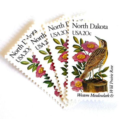 Image of North Dakota State Bird and Flower postage stamps from 1982, featuring a Western Meadowlark and Wild Prairie Rose on vintage unused 20-cent USPS postage, Scott 1986.