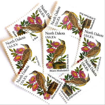 Image of North Dakota State Bird and Flower postage stamps from 1982, featuring a Western Meadowlark and Wild Prairie Rose on vintage unused 20-cent USPS postage, Scott 1986.