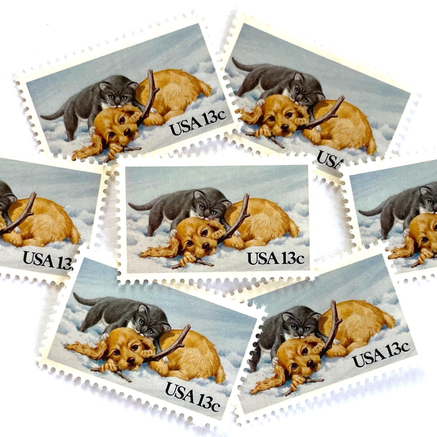 Image of 1982 Christmas Issue “Kitten and Puppy” 13-cent stamps. Scott #2025. Stamp Themes: Pets, Cat, Dog, Humane Society, Play, Snow, Winter. Light Blue postage stamp.