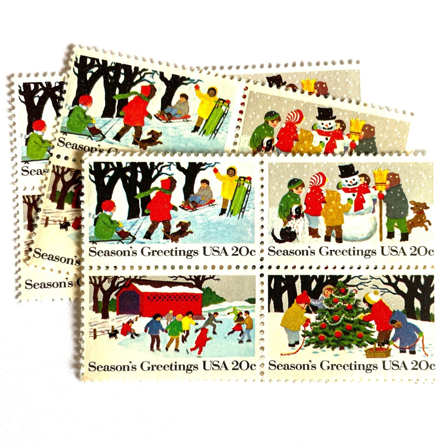 Image of 1982 Contemporary Christmas “Season's Greetings” 20 cent stamps. Scott #2027-30. Stamp Themes: Christmas, Holidays, Winter, Sledding, Ice Skating, Snowman Building, Christmas Tree Decorating, Snow, Cold, Children Playing. Christmas Issue Se-Tenant set of four connected stamps.