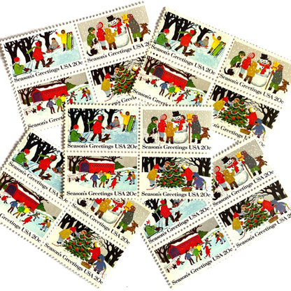 Image of 1982 Contemporary Christmas “Season's Greetings” 20 cent stamps. Scott #2027-30. Stamp Themes: Christmas, Holidays, Winter, Sledding, Ice Skating, Snowman Building, Christmas Tree Decorating, Snow, Cold, Children Playing. Christmas Issue Se-Tenant set of four connected stamps.