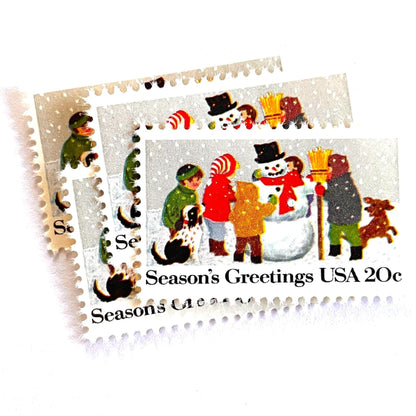 Image of 1982 Contemporary Christmas “Building a Snowman” 20-cent stamps. Scott #2028. Stamp Themes: Snowman, Christmas, Holidays, Winter, Children, Playing, Snowing, Season’s Greetings. White postage stamp.