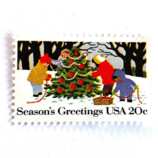 Image of 1982 Contemporary Christmas “Decorating the Tree” 20-cent stamps. Scott #2030. Stamp Themes: Christmas Tree, Tree Trimming, Holidays, Snow, Winter Scene, Season's Greetings. Multicolored postage stamp.