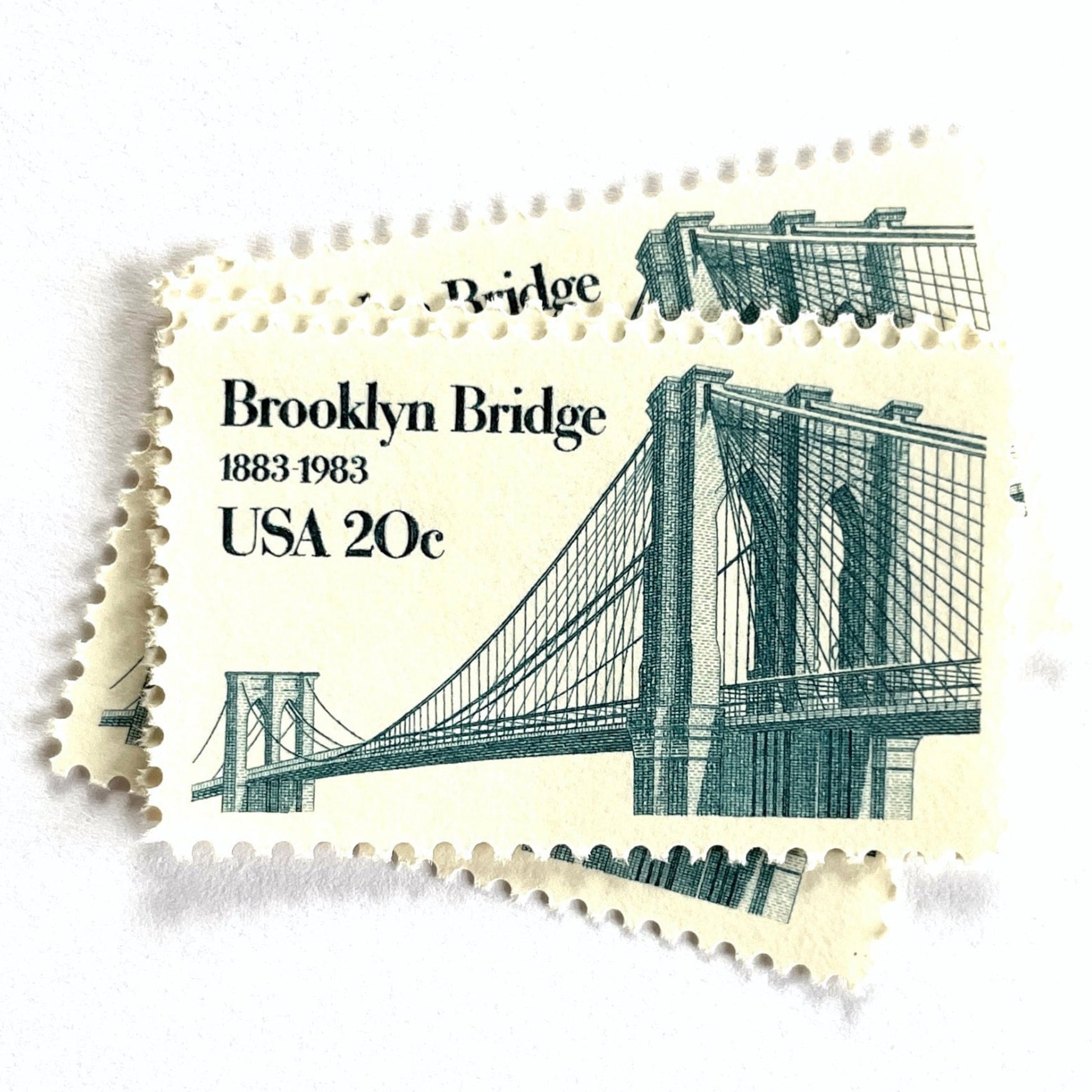 Image of 1983 “Brooklyn Bridge” 20-cent mail stamps. Scott #2041. Stamp Themes: 100th Anniversary of the Brooklyn Bridge, 8th Wonder of the World, NYC, New York City, Brooklyn. Blue postage stamp.