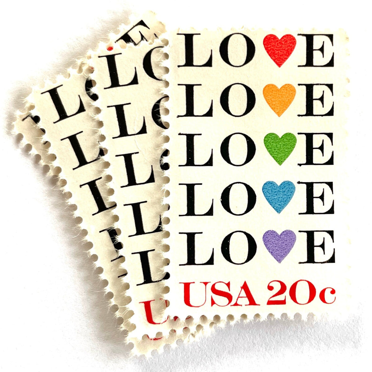 Love with Hearts postage stamps from 1984 featuring repeated LOVE lettering with five different-colored hearts on vintage unused 20-cent USPS postage, Scott 2072.
