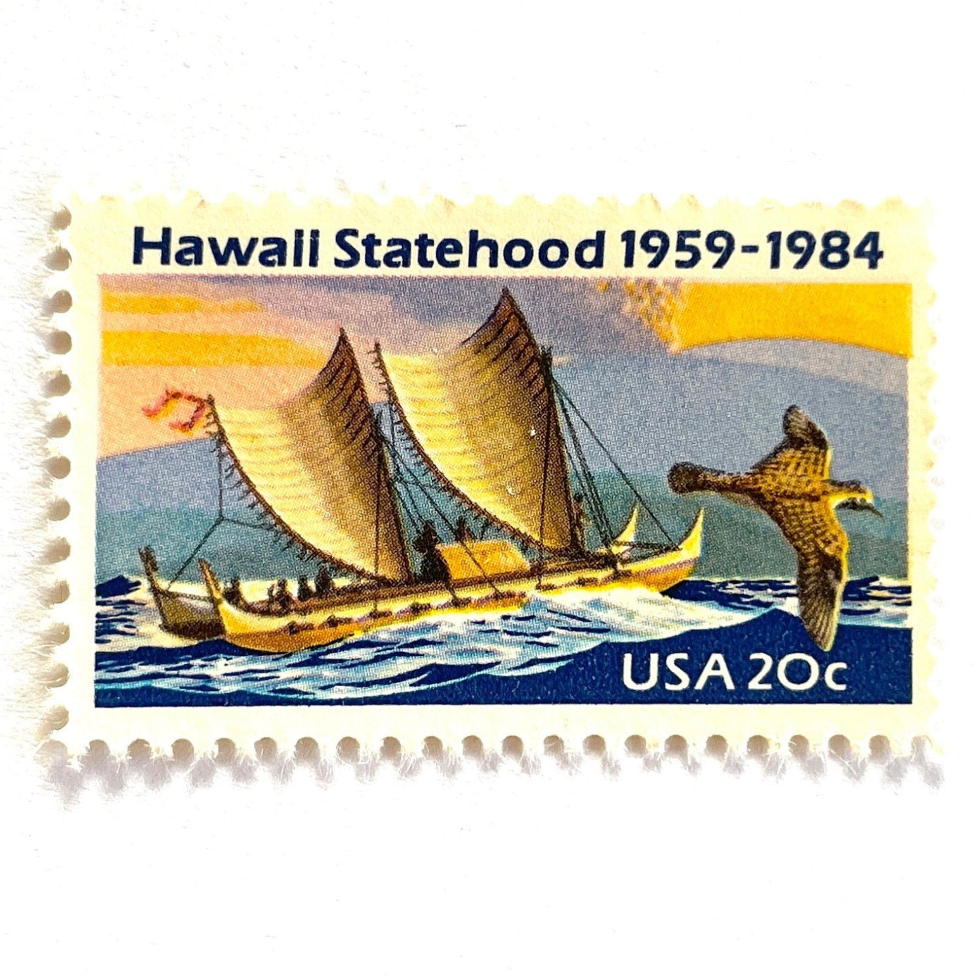 Image of Hawaii Statehood postage stamps from 1984, featuring a Polynesian voyaging canoe on the ocean, a golden plover in flight, and an erupting Mauna Loa volcano on vintage unused 20-cent USPS postage, Scott 2080.