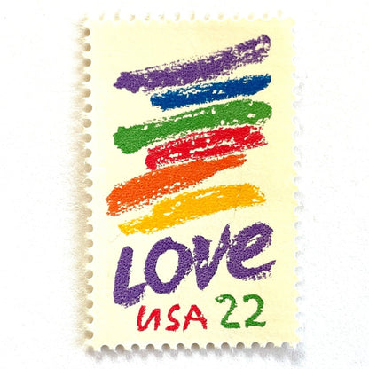 Love Crayon postage stamp from 1985 featuring colorful brush strokes and bold purple LOVE lettering on vintage unused 22-cent USPS postage, Scott 2143.